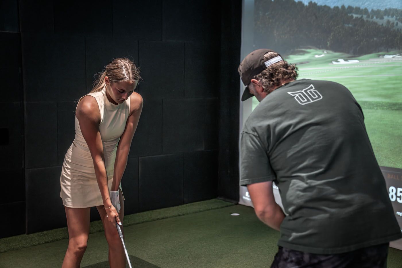 An image of a woman working with a Tee Box golf swing coach in Tucson, AZ.