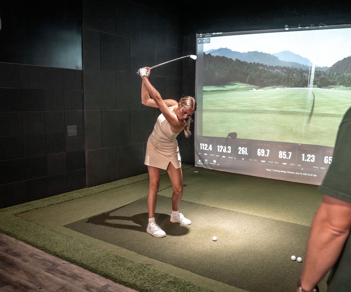 A woman meeting with a Tee Box coach for Delray Beach ladies golf lessons.