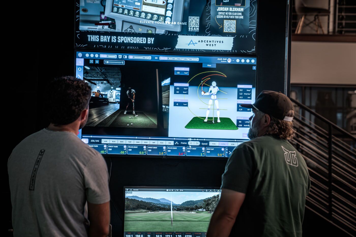 A golf pro and golfer looking at measurements from the trackman golf sim in Delray Beach, FL at Tee Box.