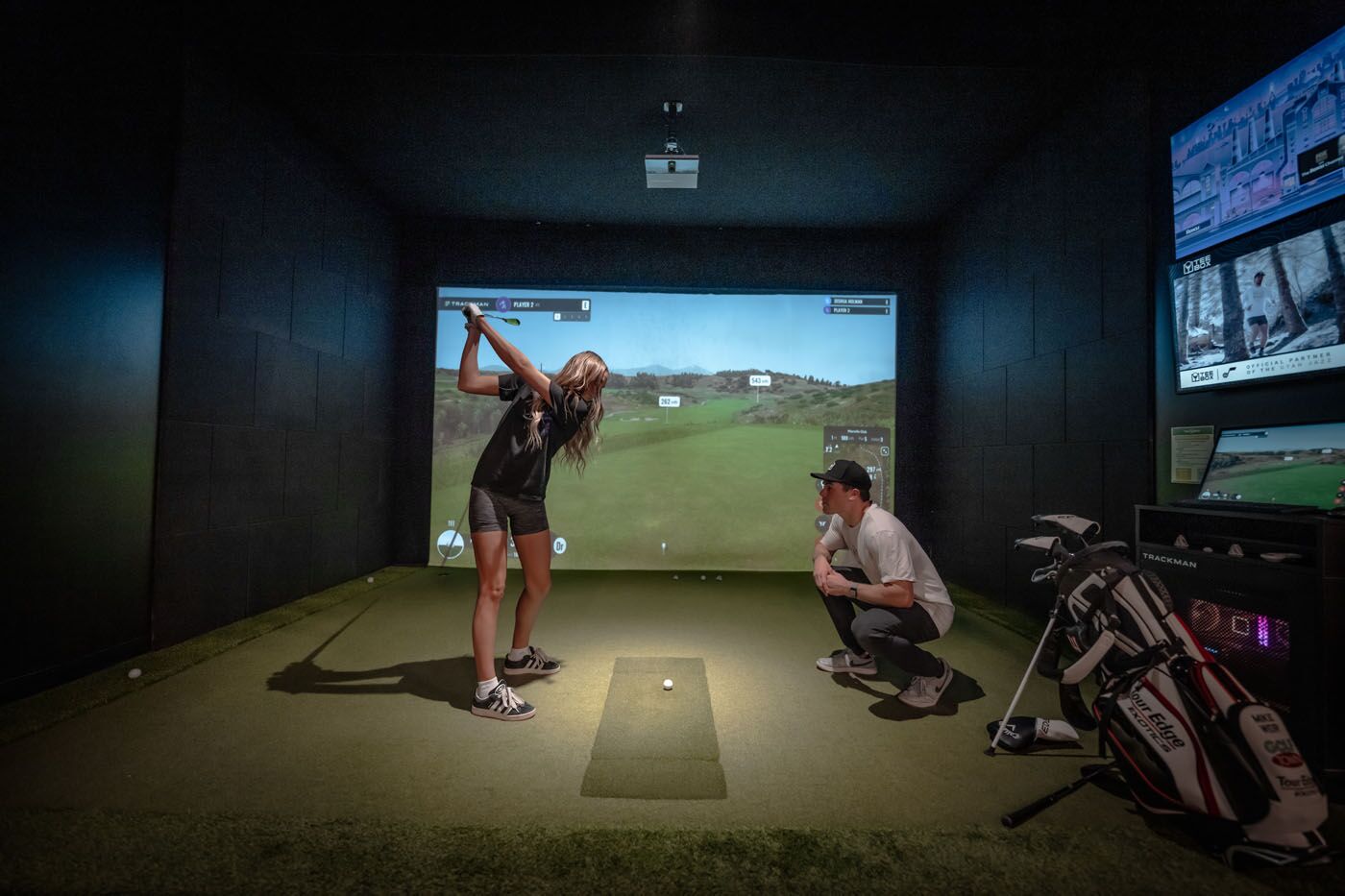 A golfer receiving professional golf training in Omaha, NE at an indoor Tee Box facility.