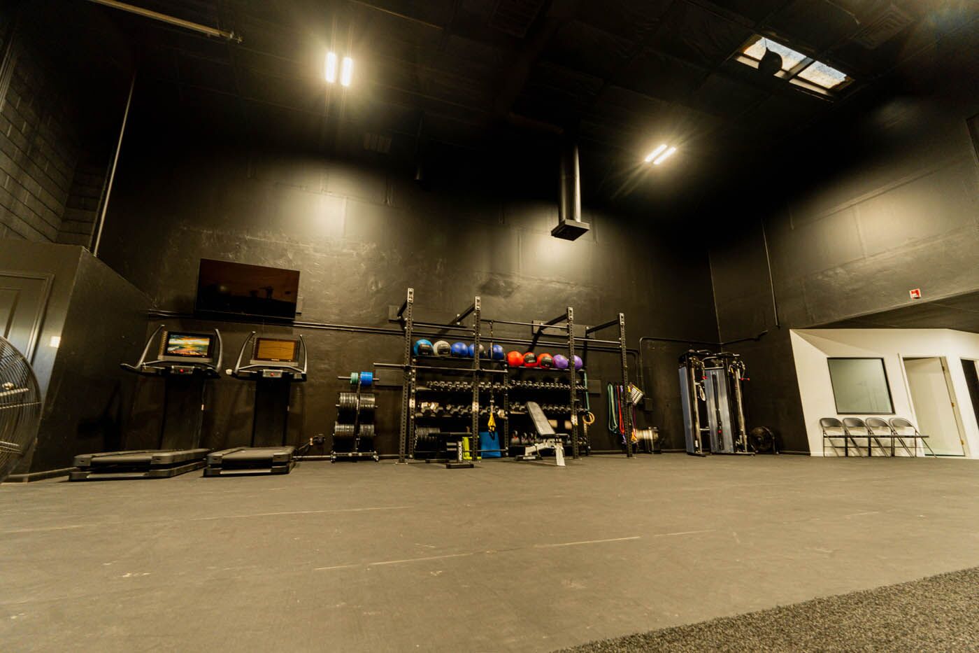 Tee Box St. George full gym view with tv and treadmills.