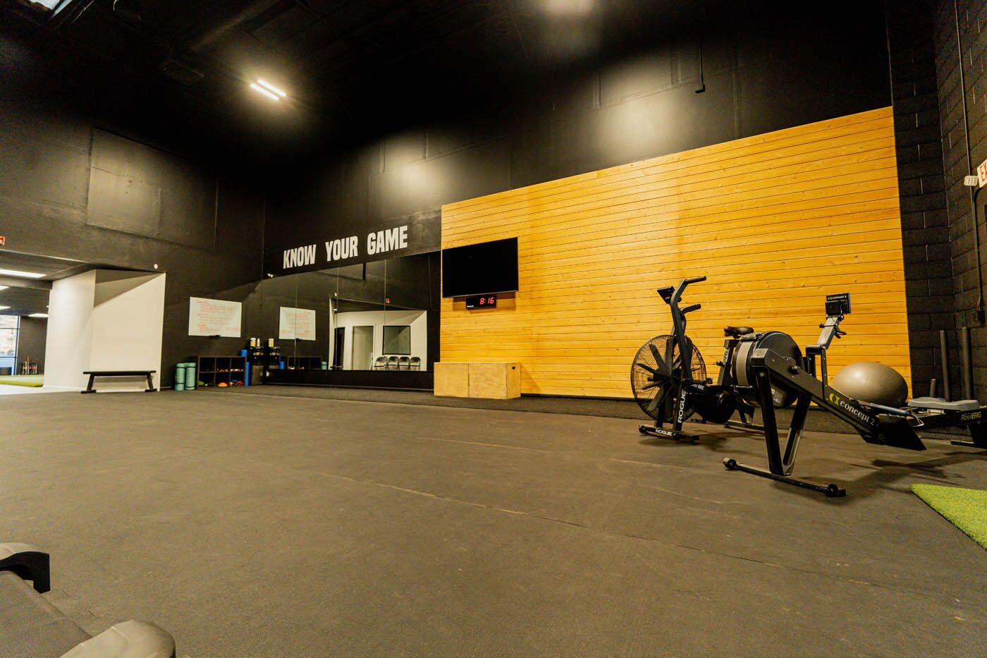 Tee Box St. George full gym view with assault bikes and entrance.