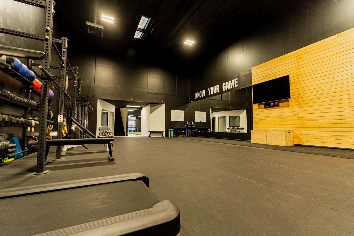 Tee Box St. George full gym view with entrance and treadmills.