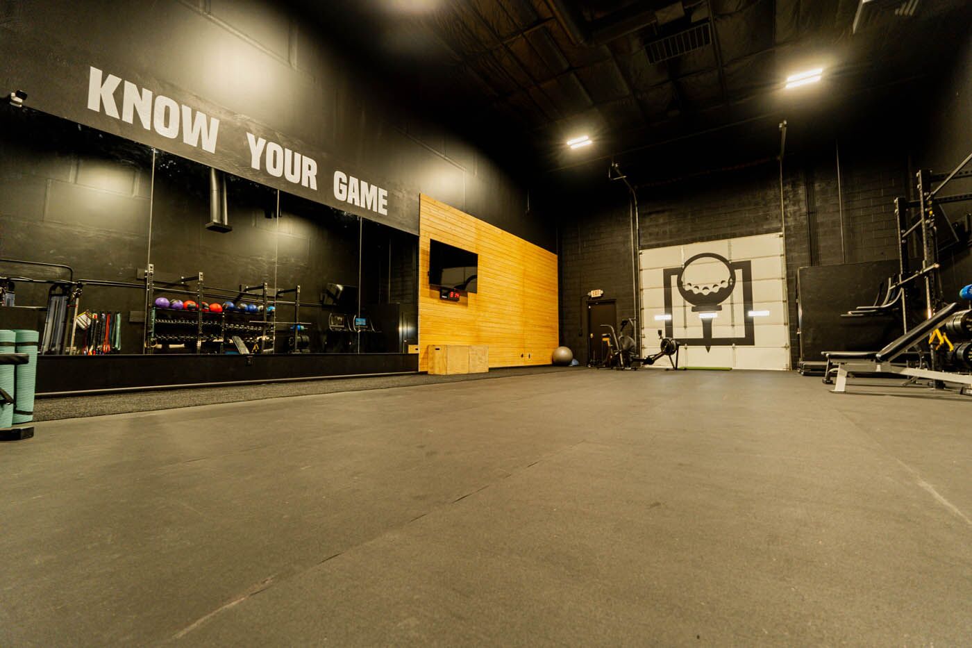 Tee Box St. George gym wall with mirrors and Tee Box logo.