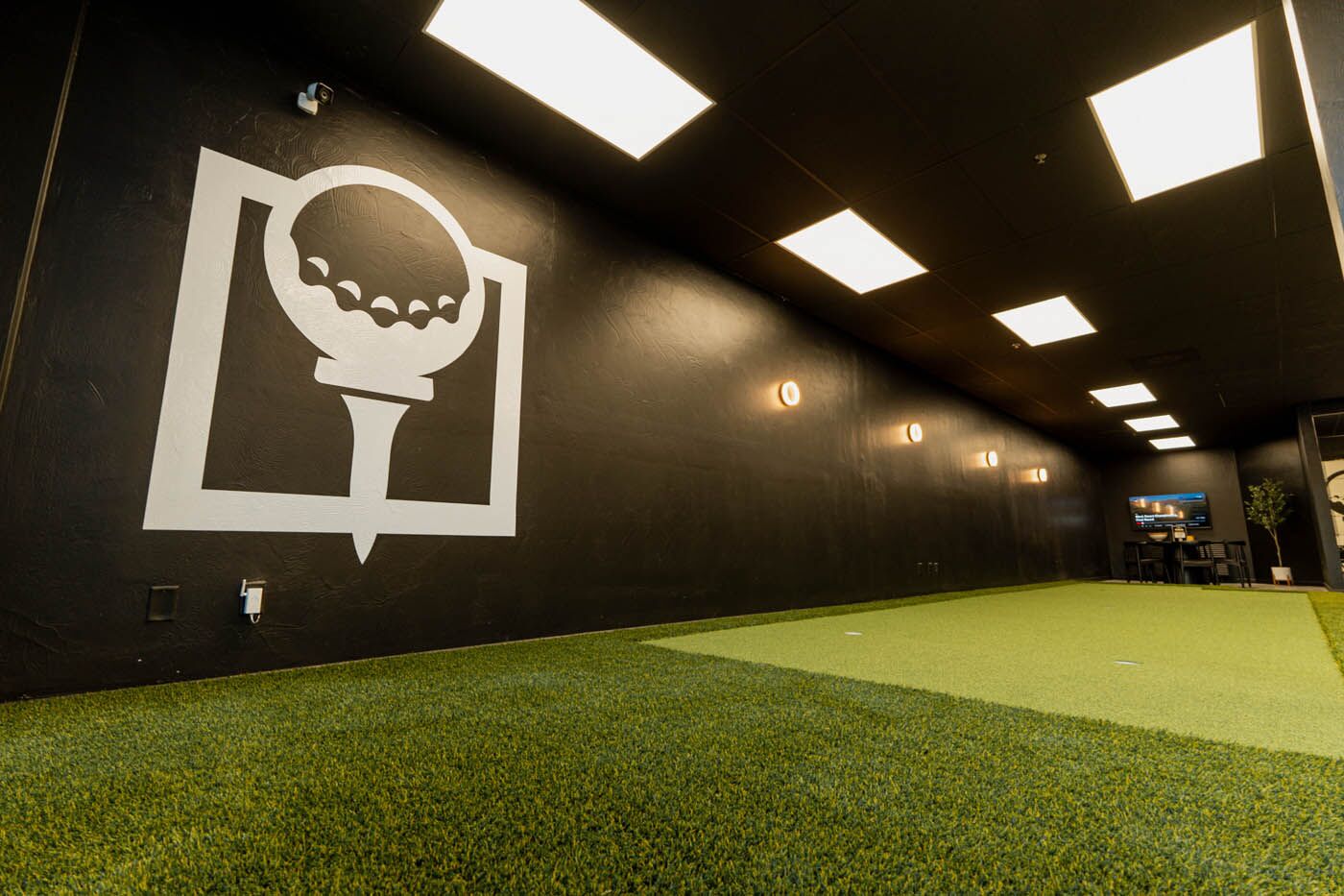 Tee Box St. George indoor putting area with Tee Box logo.