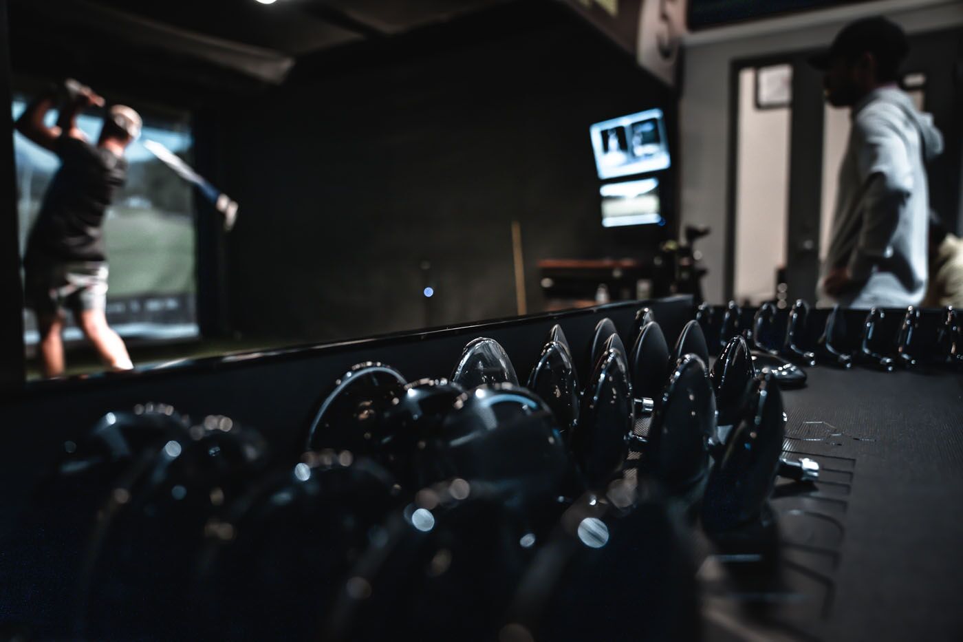 An image of Tee Box Fort Lauderdale equipment and a golfer using our sim bay.