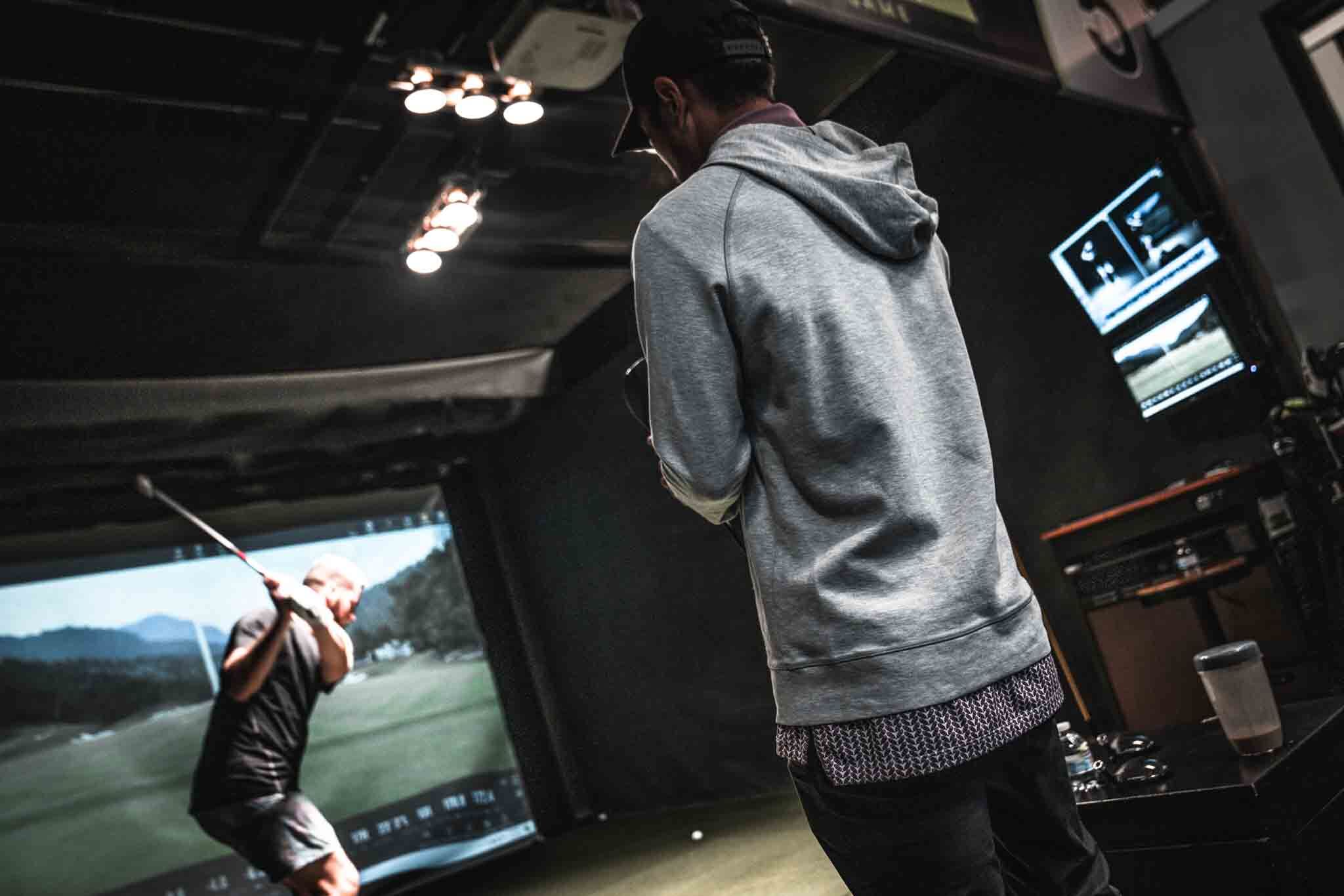 Two golfers in the Tee Box golf community in Pleasant Grove, UT using the sim bays.